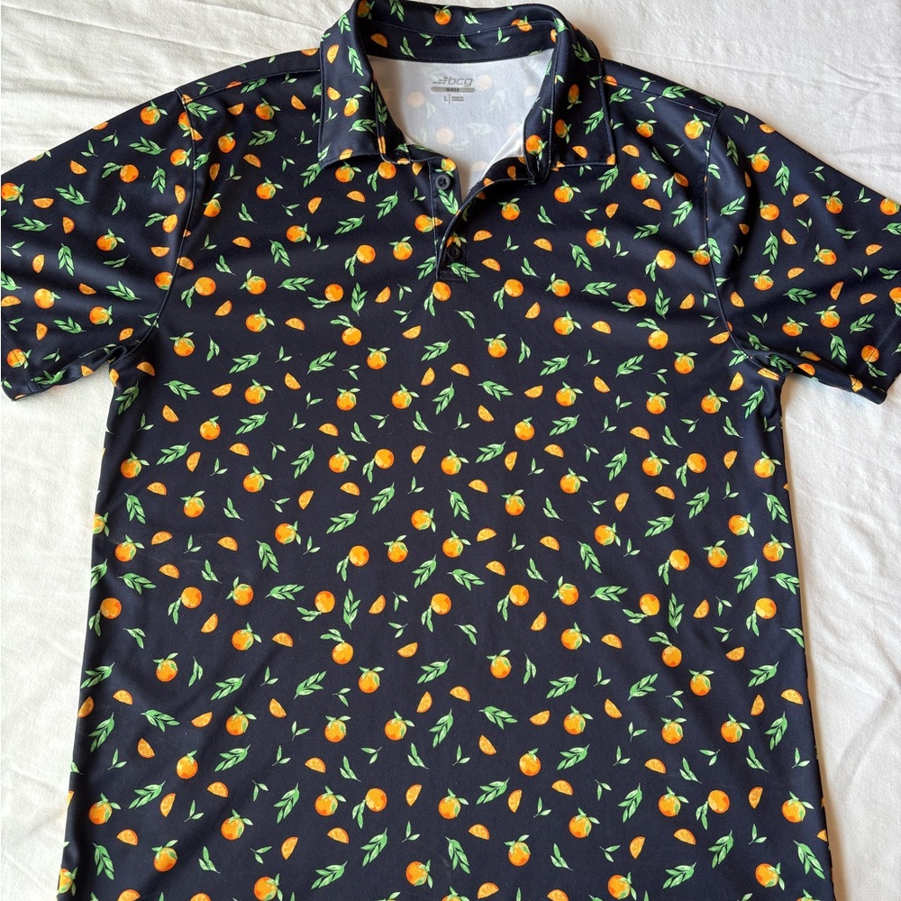 bcg Men’s Golf Orange Polo shirt features a navy background with all over citrus